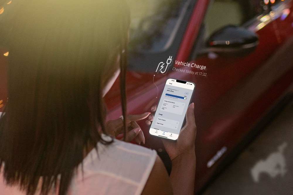 Person using FordPass by a Red Ford Mustang Mach-E