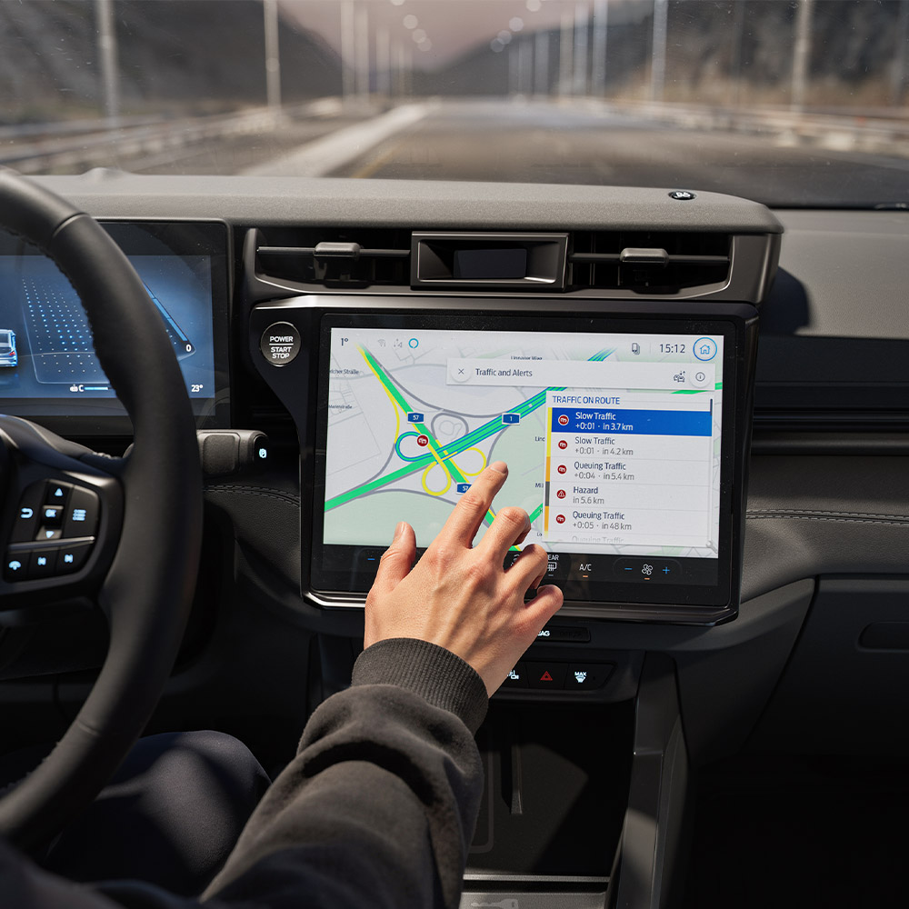 A driver using the Connected Navigation feature on the digital screen in a Ford Puma Gen-E BlueCruise Edition.