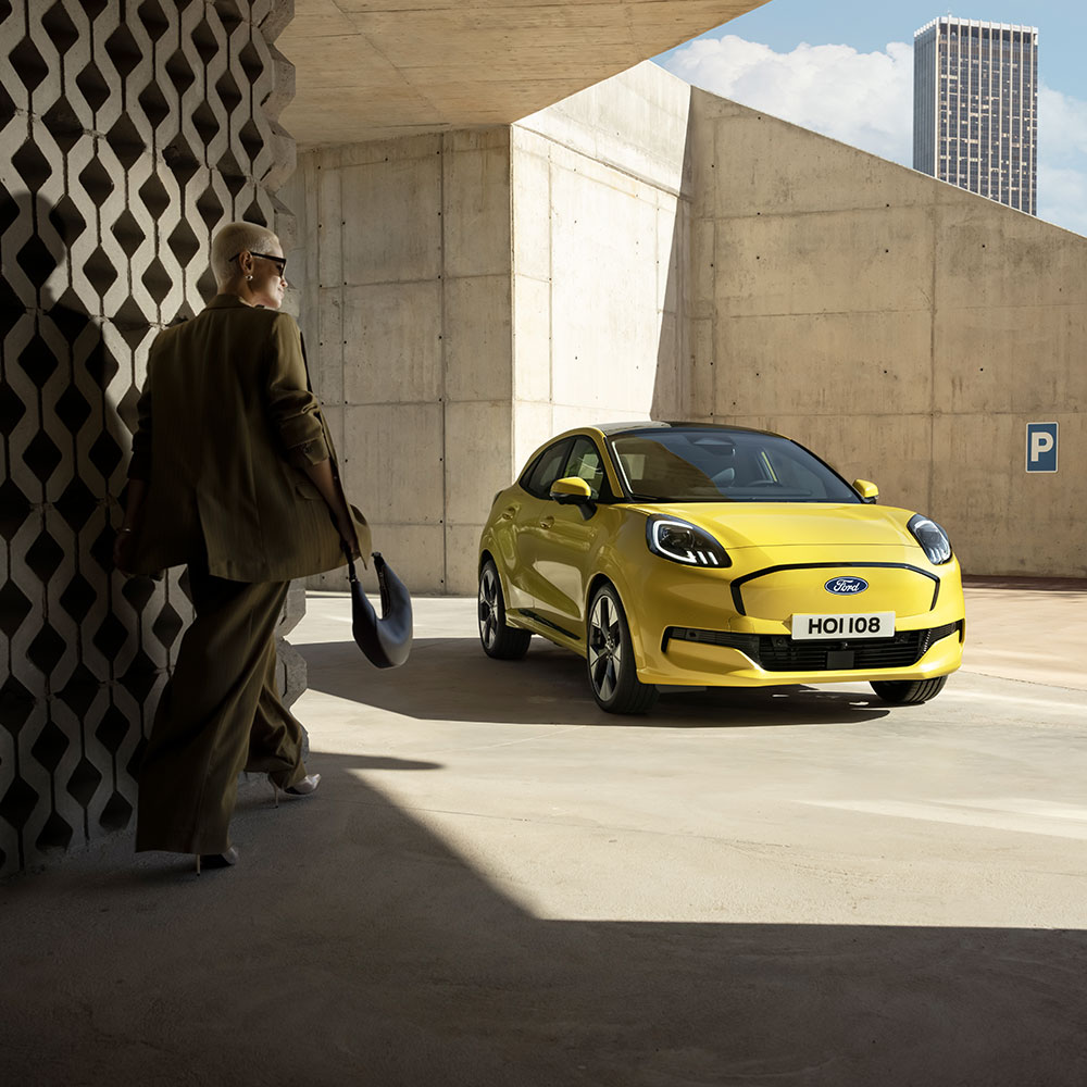 A person walks towards the electric Ford Puma Gen-E® in yellow.