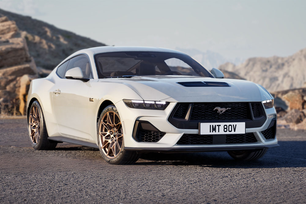 A Ford Mustang GT Fastback with Bronze Pack in Oxford White paint parked on a mountain road.