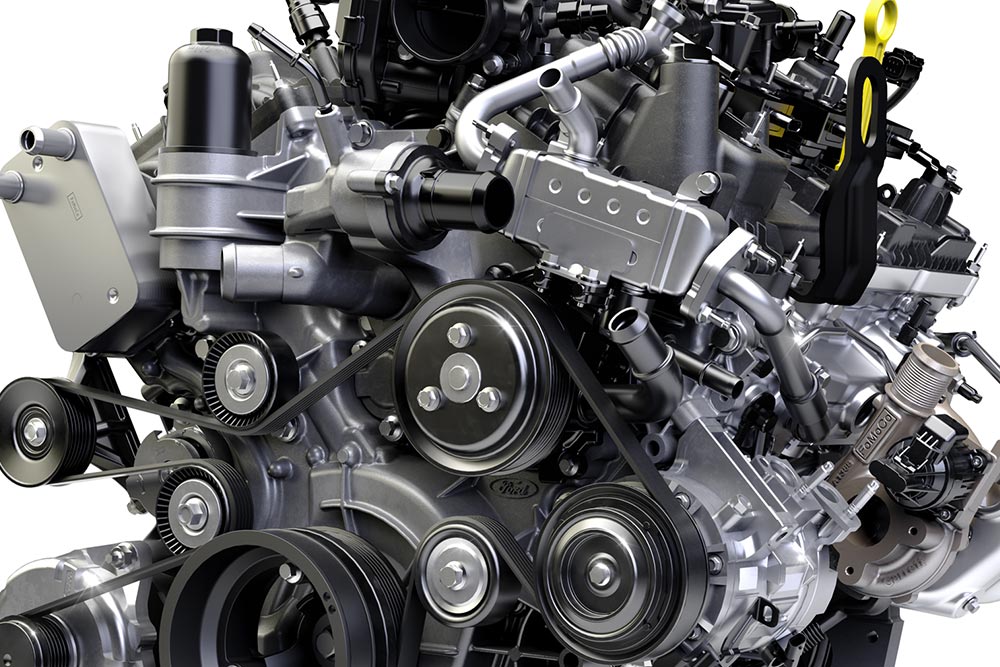 Close-up of a vehicle engine showing multiple belts, pulleys, and mechanical components.