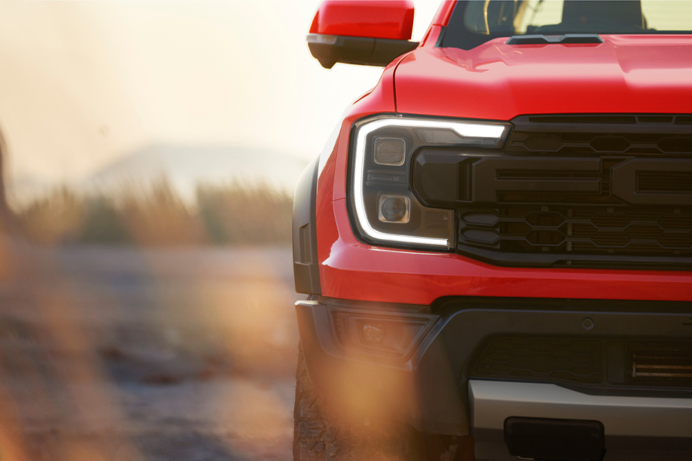 Close up of the front grille of a red Ford Ranger Raptor.