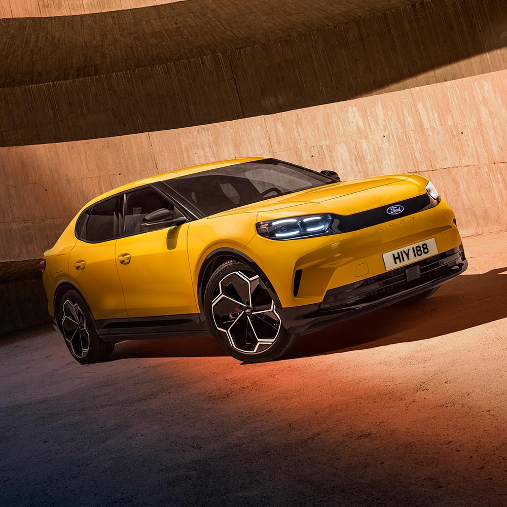 Yellow Ford Capri electric SUV in a concrete setting.